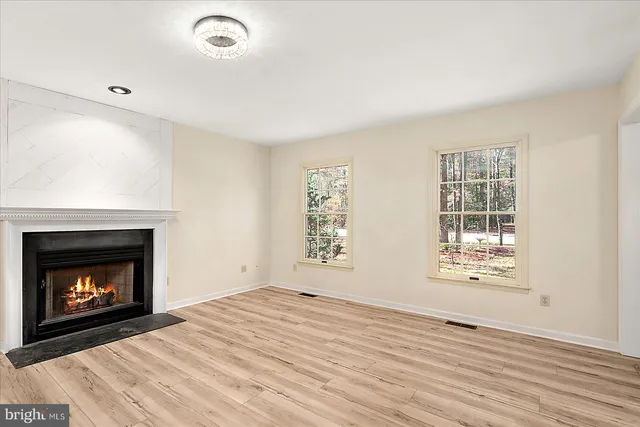 a view of empty room with wooden floor and fireplace