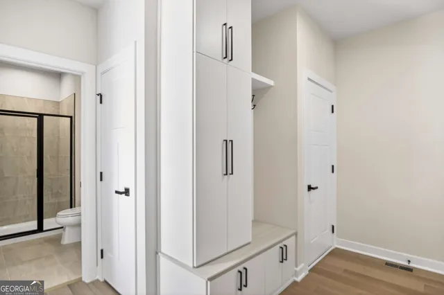 an empty room with wooden floor and windows