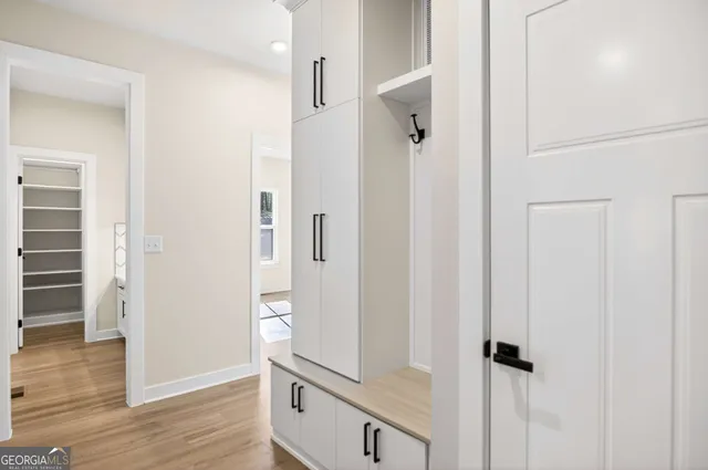 an empty room with wooden floor and a hallway
