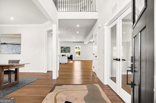 a view of a hallway with wooden floor and furniture
