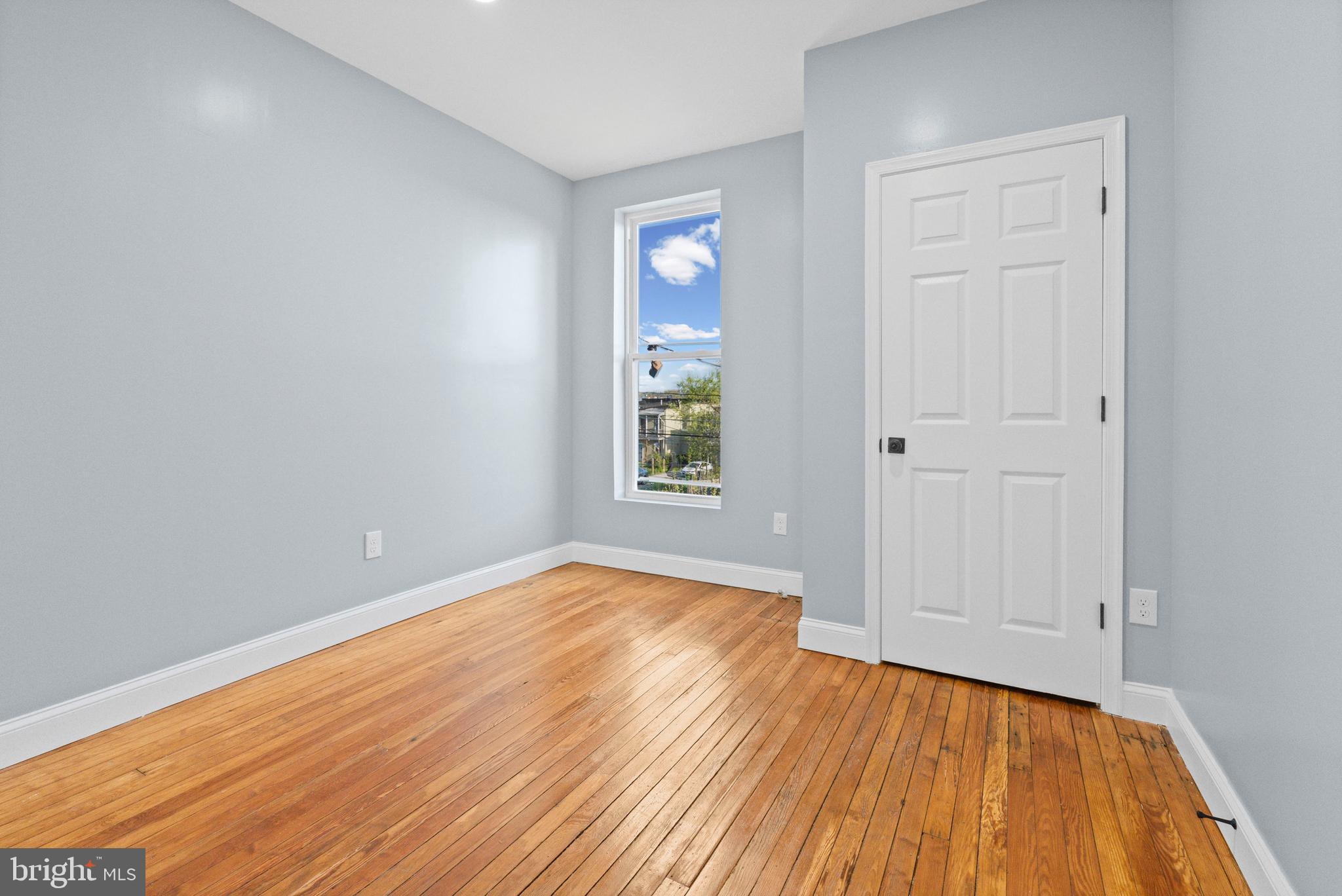 2806 Riggs Avenue Baltimore, MD 21216 - Photo 17 of 32 a view of an empty room with wooden floor and a window
