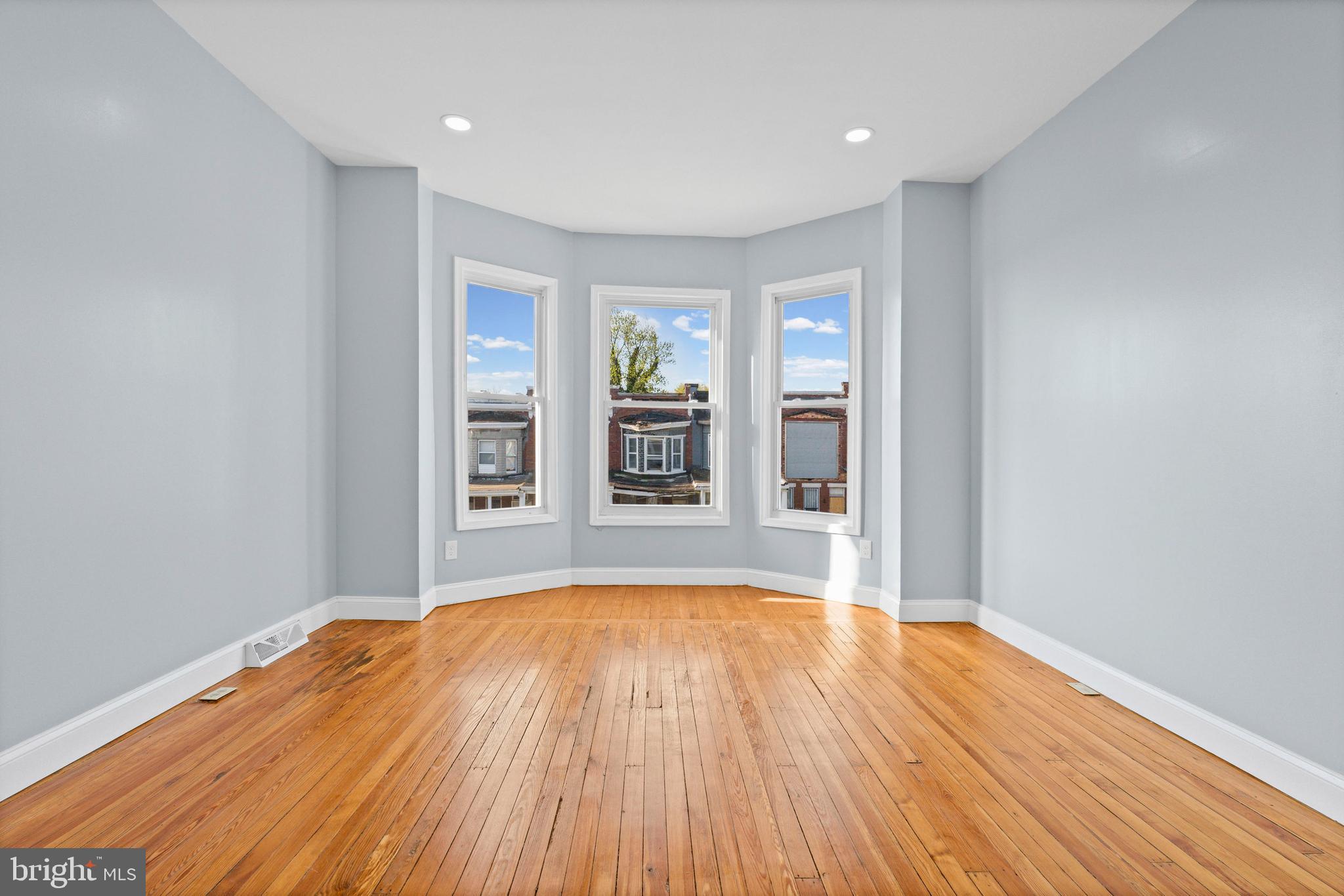 2806 Riggs Avenue Baltimore, MD 21216 - Photo 26 of 32 a view of an empty room with wooden floor and a window