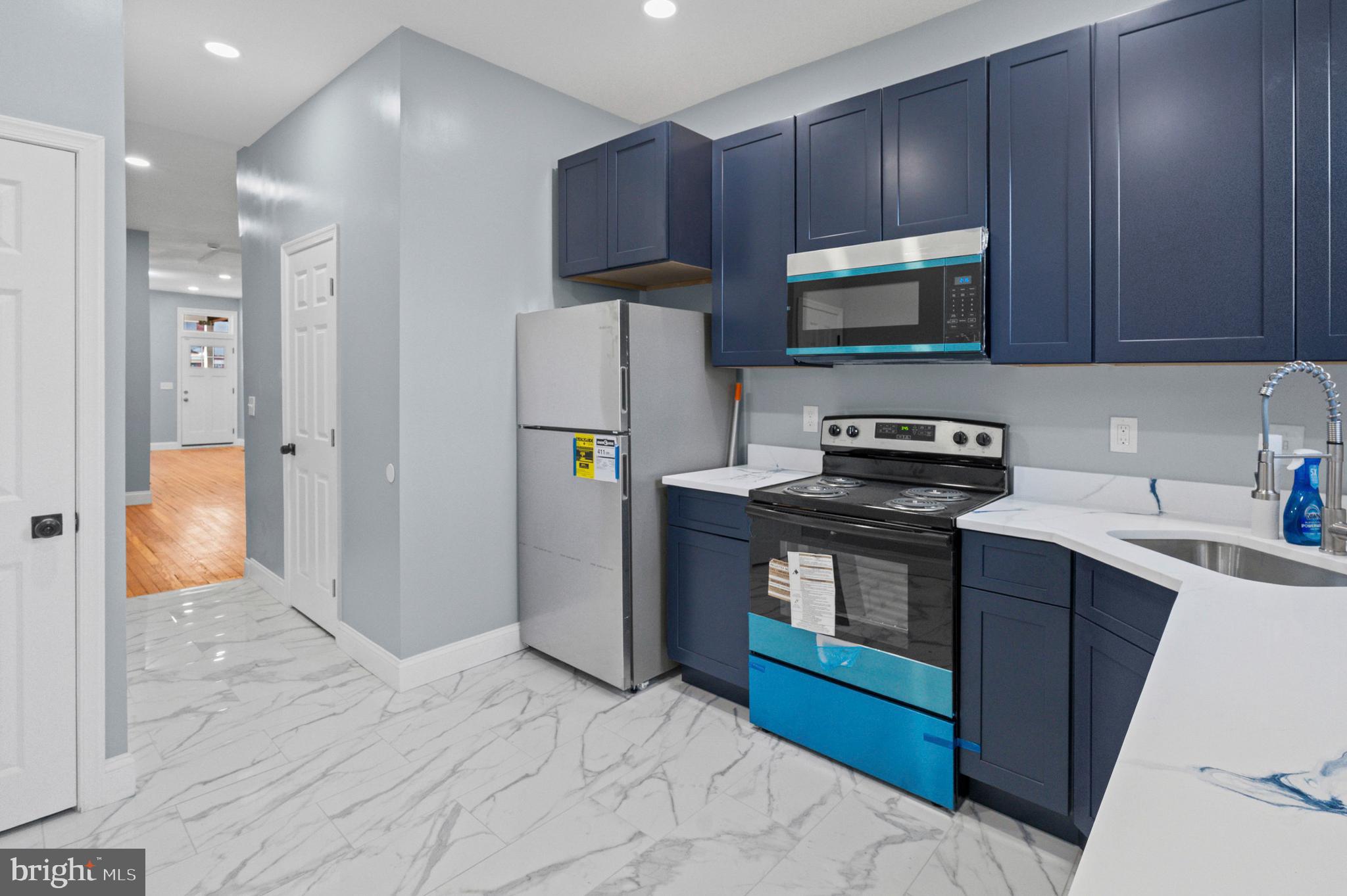 2806 Riggs Avenue Baltimore, MD 21216 - Photo 27 of 32 a kitchen with stainless steel appliances granite countertop a refrigerator stove and microwave