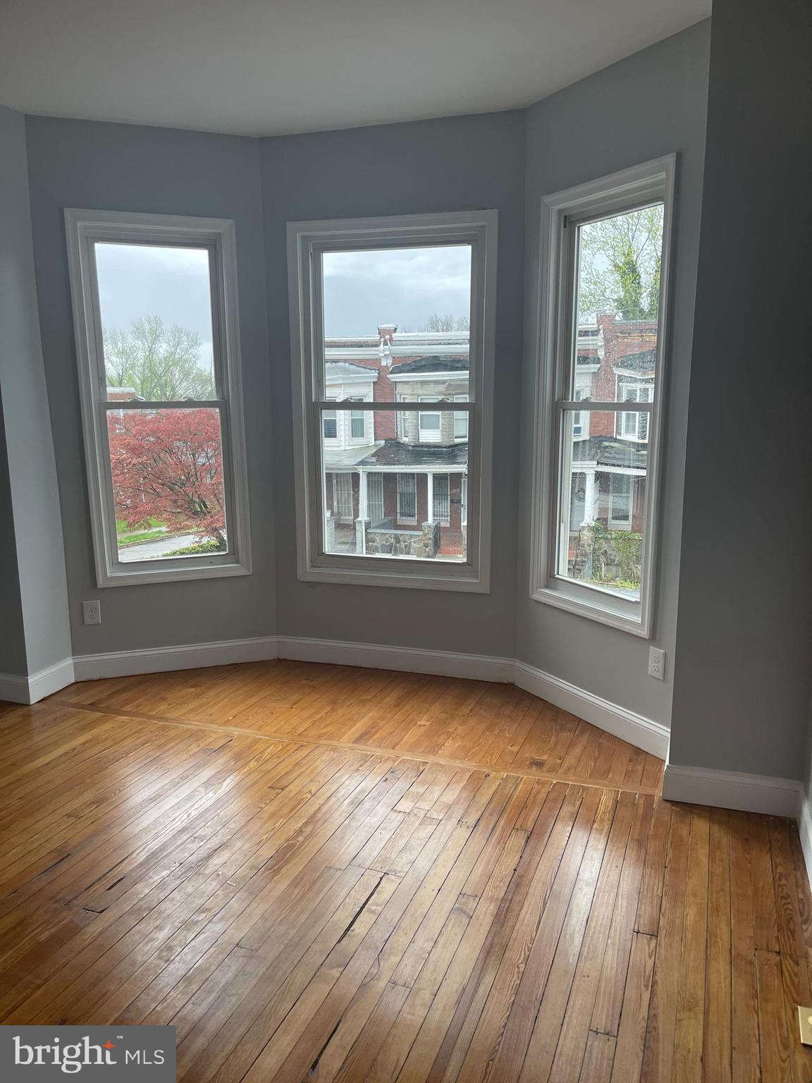 2806 Riggs Avenue Baltimore, MD 21216 - Photo 5 of 32 a view of an empty room with wooden floor and a window