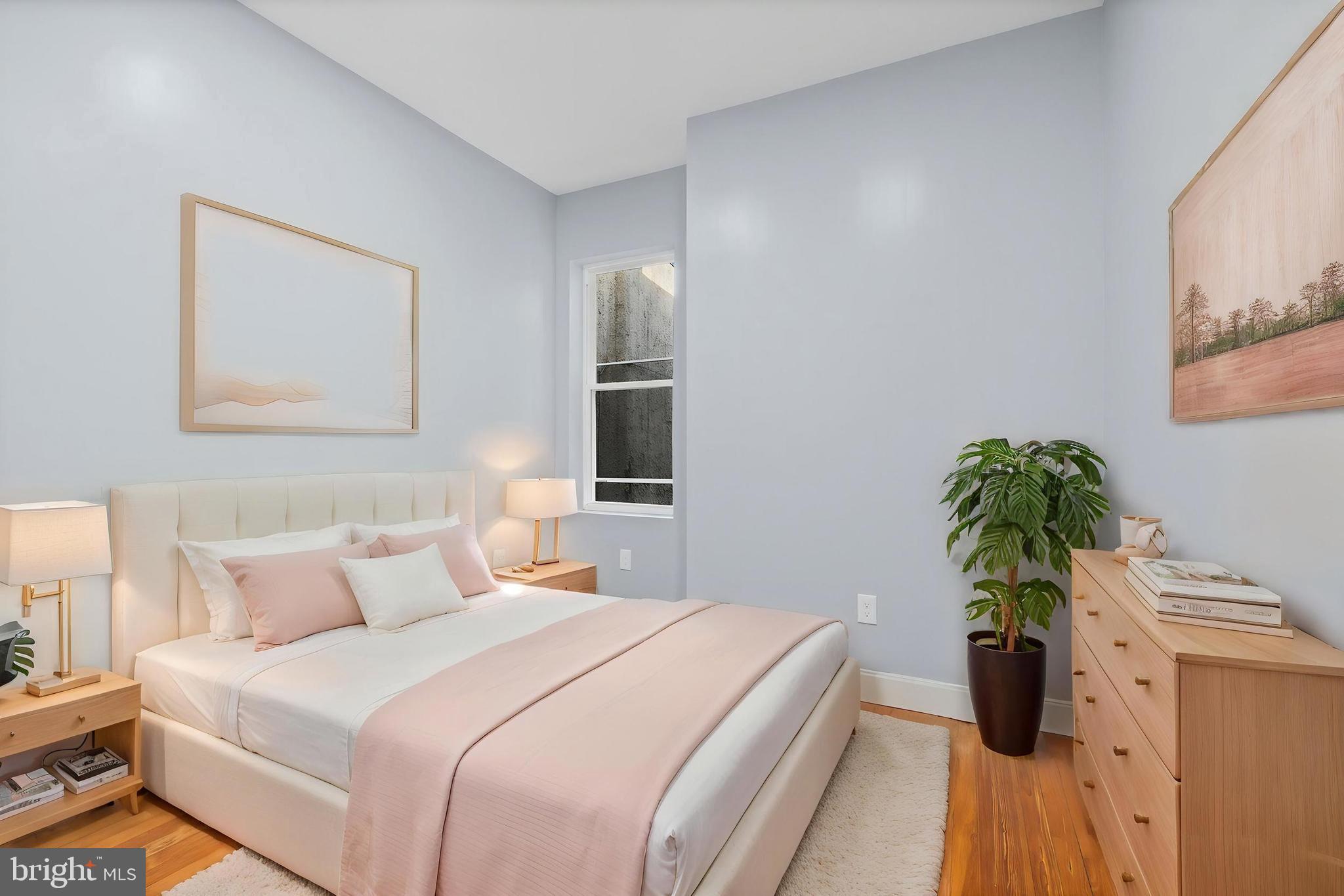 2806 Riggs Avenue Baltimore, MD 21216 - Photo 7 of 32 a bedroom with a bed and a potted plant