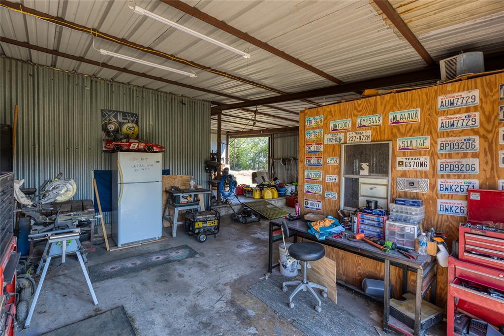6473 West Highway 199 Springtown, TX 76082 - Photo 30 of 40 Garage with metal wall, freestanding refrigerator, and a workshop area