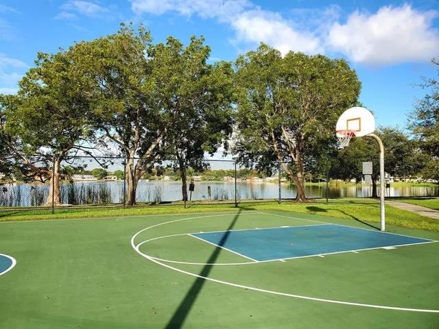 a view of a lake with a yard and large trees