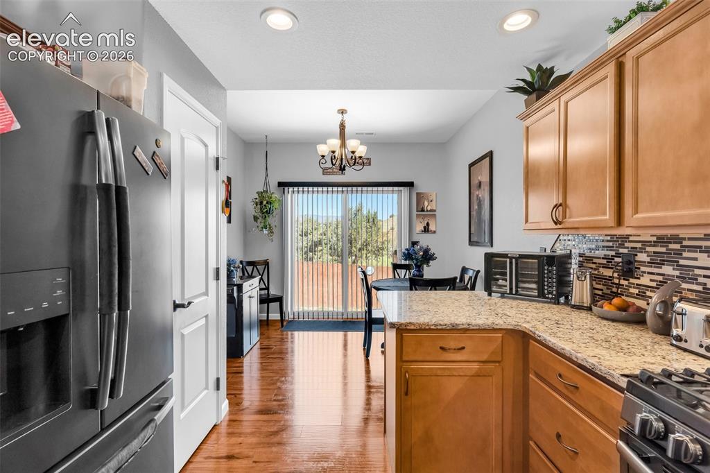 415 Empire Road Canon City, CO 81212 - Photo 16 of 40 a kitchen with stainless steel appliances granite countertop a refrigerator a sink dishwasher a stove and white countertops with wooden floor