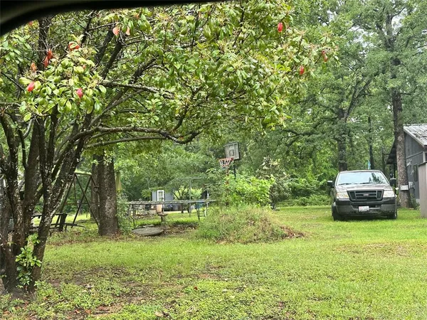 a car parked in front of a house with a big yard