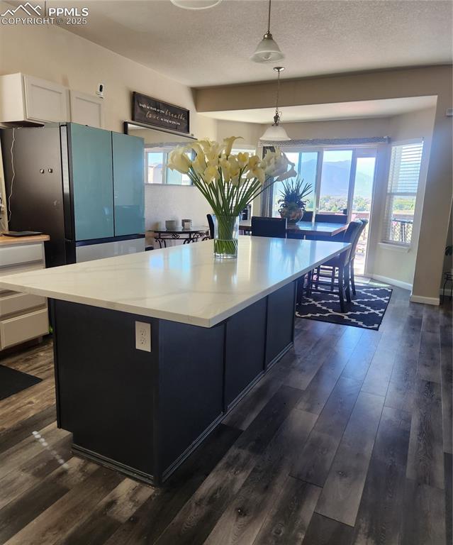 4530 Sierra Rica Road Colorado Springs, CO 80911 - Photo 13 of 44 a view of kitchen with refrigerator microwave and wooden floor