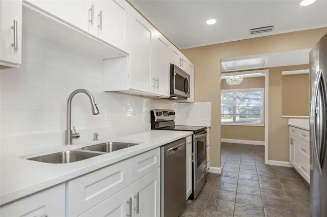 a kitchen with white cabinets and a sink