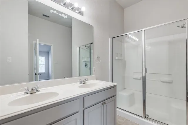 a bathroom with a shower sink vanity and mirror