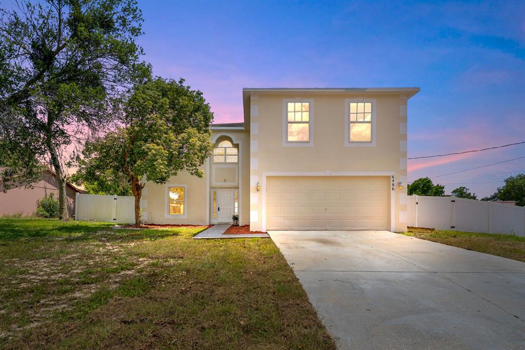 6486 Toledo Road Spring Hill, FL 34606 - Photo 1 of 1 a front view of a house with a yard