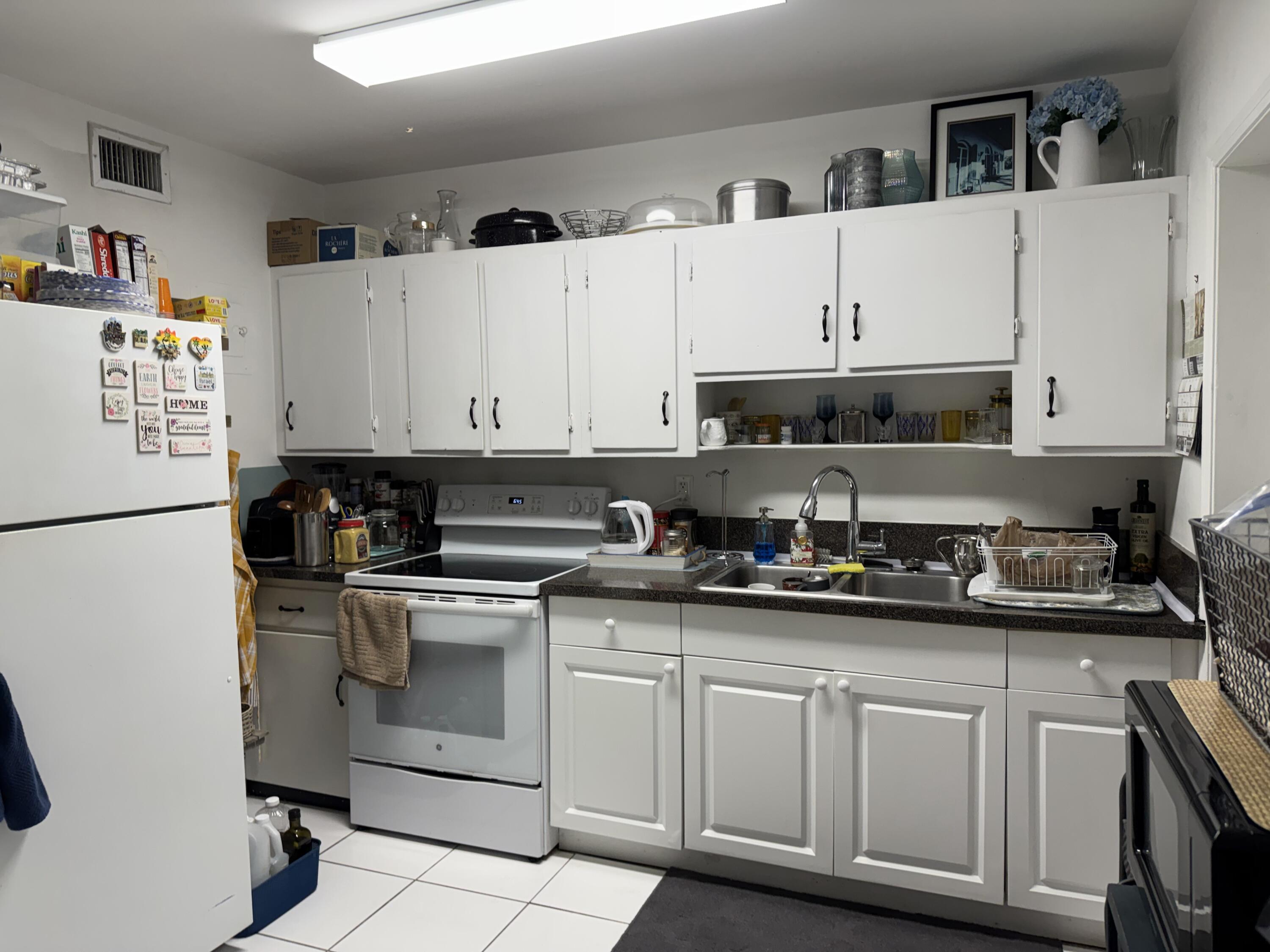 1612 Laird Street Key West, FL 33040 - Photo 15 of 18 a white kitchen with granite countertop a sink and white stainless steel appliances