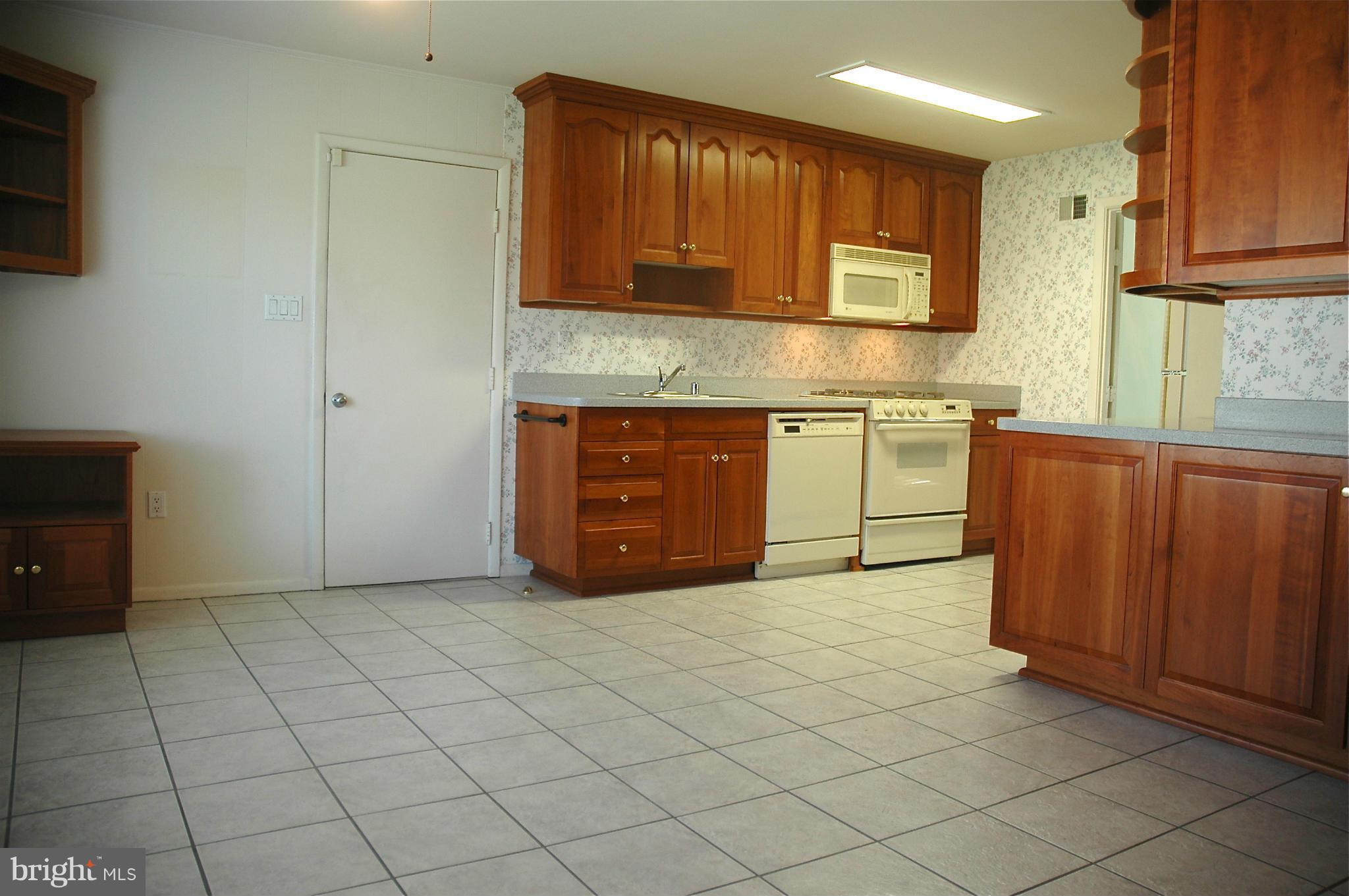 14717 Flintstone Lane Silver Spring, MD 20905 - Photo 12 of 26 a kitchen with stainless steel appliances granite countertop a stove a sink and a microwave