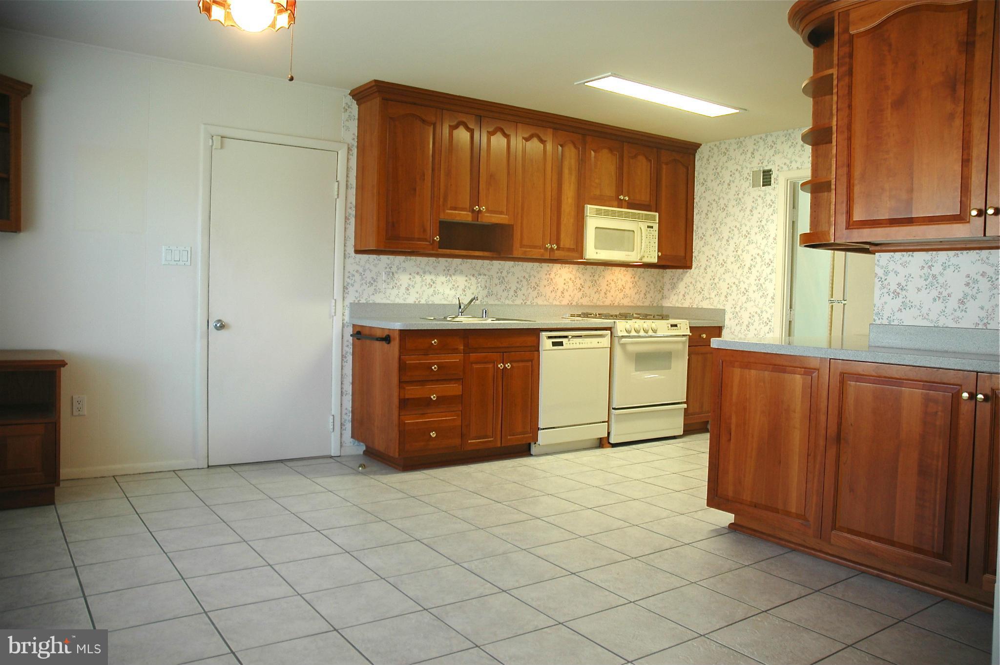 14717 Flintstone Lane Silver Spring, MD 20905 - Photo 13 of 26 a kitchen with stainless steel appliances granite countertop a stove a sink and a microwave
