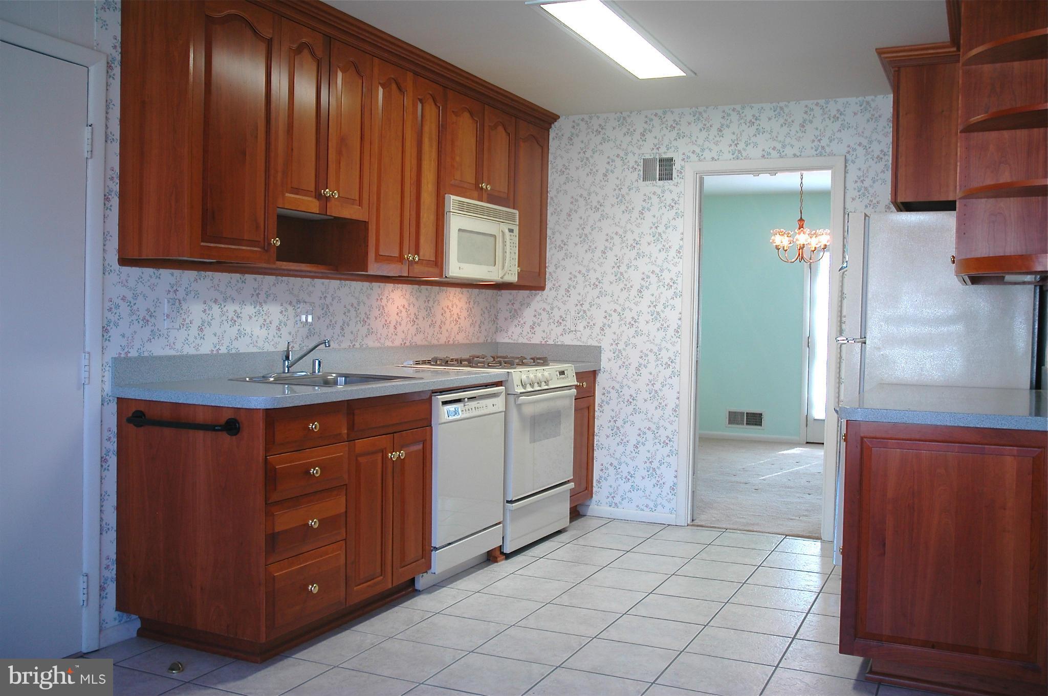 14717 Flintstone Lane Silver Spring, MD 20905 - Photo 7 of 26 a kitchen with stainless steel appliances granite countertop a stove a sink and a refrigerator