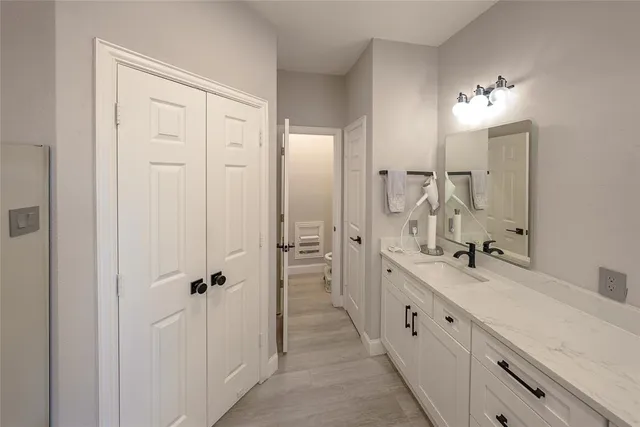 a bathroom with a double vanity sink a large mirror and a bathtub