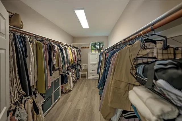 a view of walk in closet with clothes and shoes