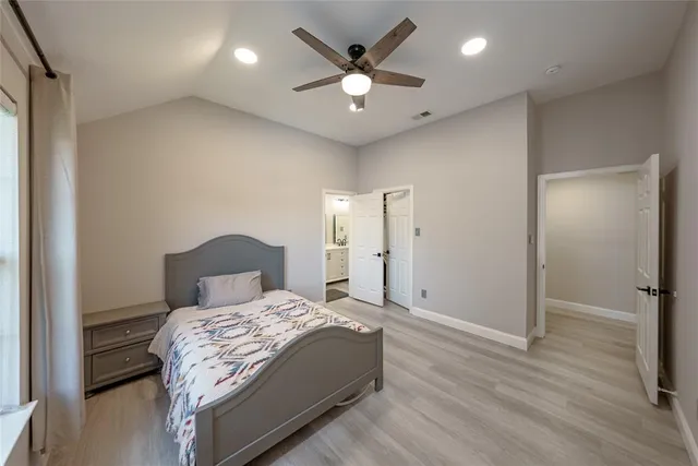 a bedroom with a large bed and a chandelier
