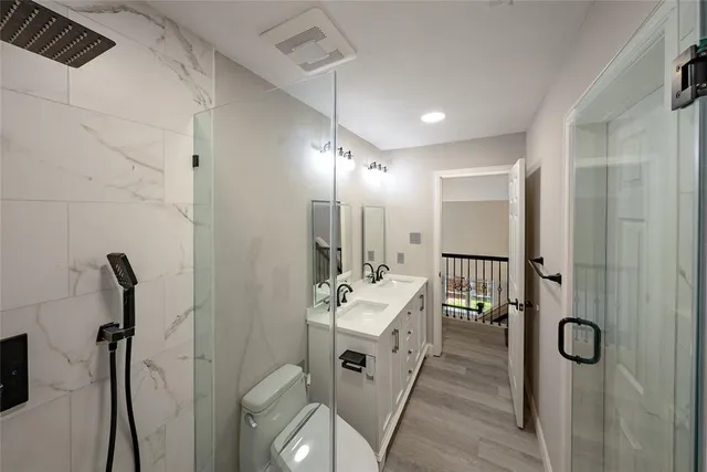 a bathroom with a double vanity sink mirror and shower