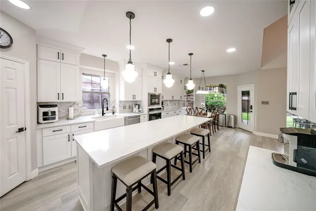 a large kitchen with kitchen island a large island a sink appliances and a counter top space