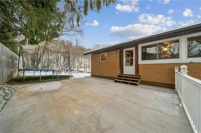 a view of backyard with barbeque grill and brick wall