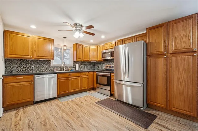 a kitchen with stainless steel appliances granite countertop a refrigerator a sink and dishwasher