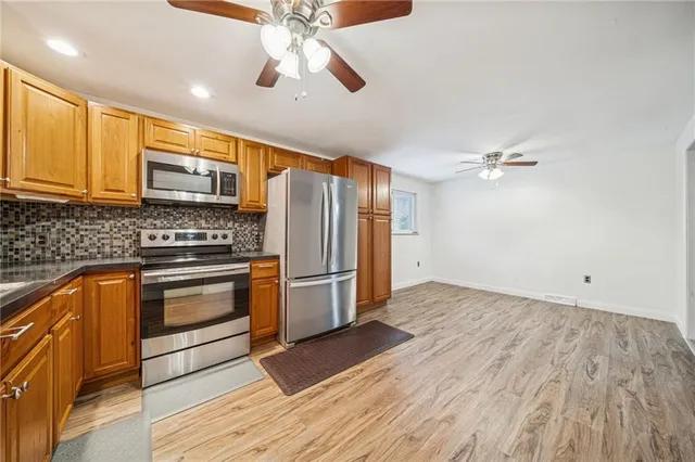 a kitchen with granite countertop a stove cabinets and stainless steel appliances