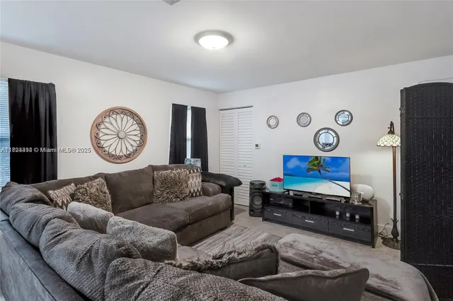 a living room with furniture a clock and a flat screen tv