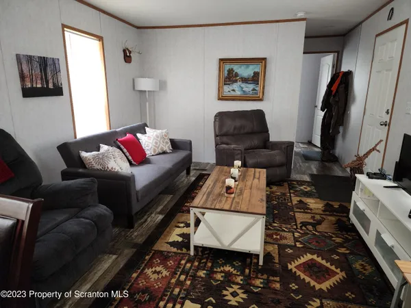 a living room with furniture a flat screen tv and a window