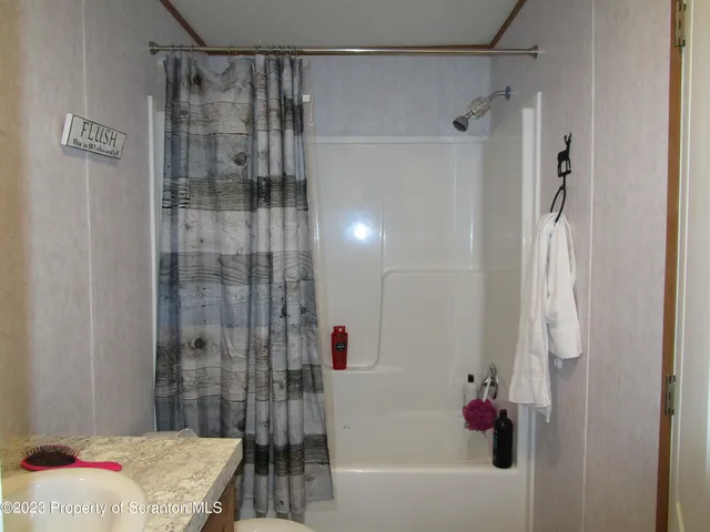 a bathroom with a shower and a sink