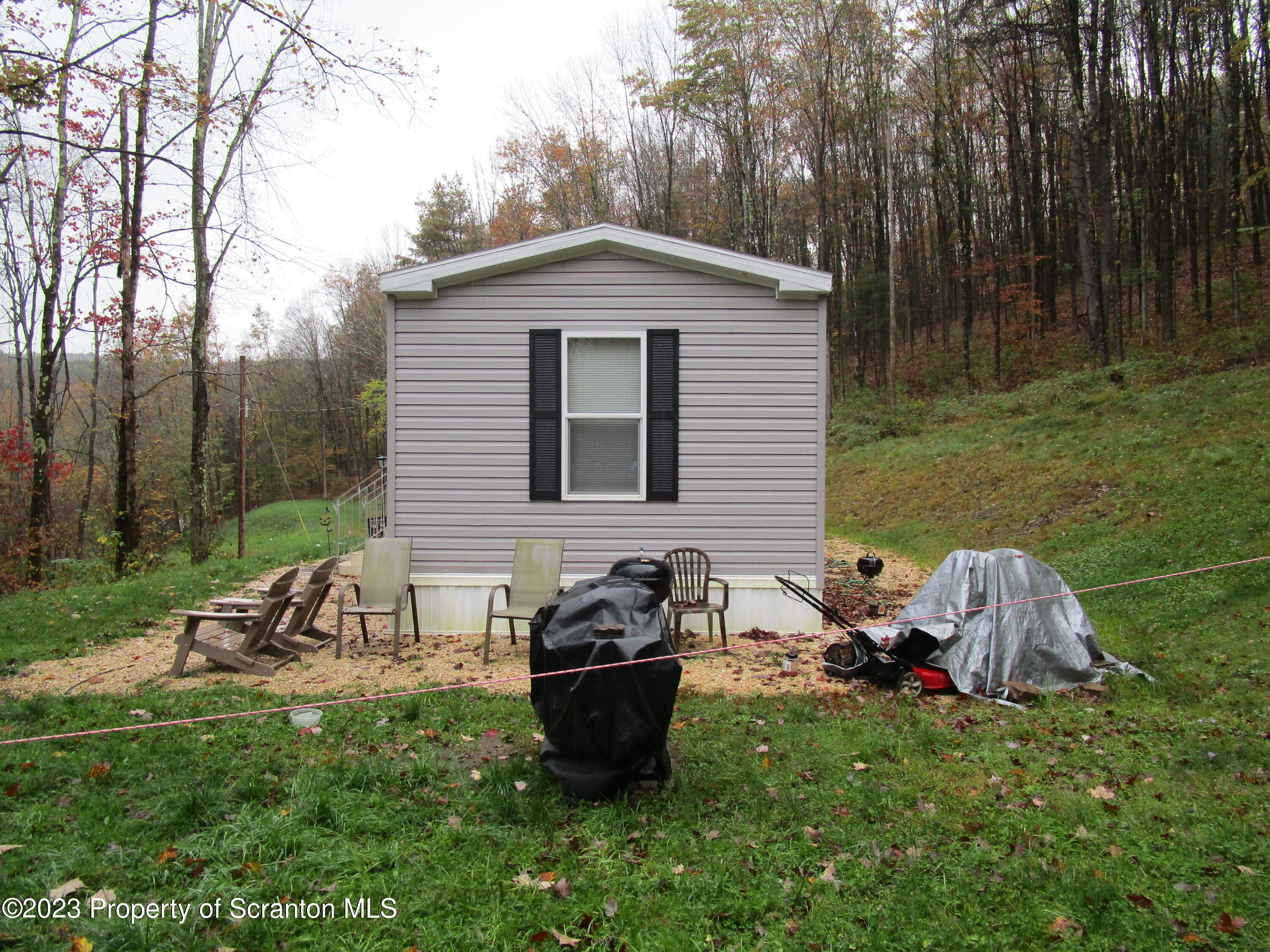 853 Silver Creek Road Montrose, PA 18801 - Photo 2 of 20 a view of a backyard with table and chairs potted plants and a large tree