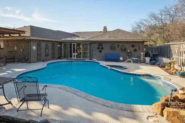 a view of swimming pool with outdoor seating and house in the background
