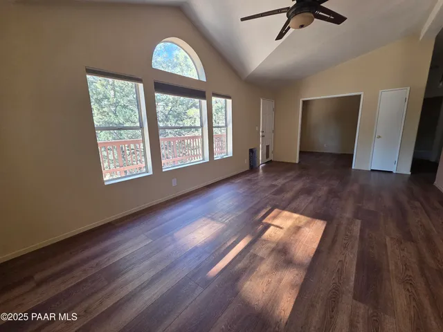 a view of a room with wooden floor and ceiling fan