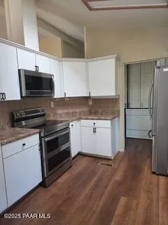 an empty room with a ceiling fan and windows