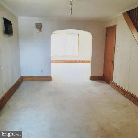 an empty room with wooden floor and mirror