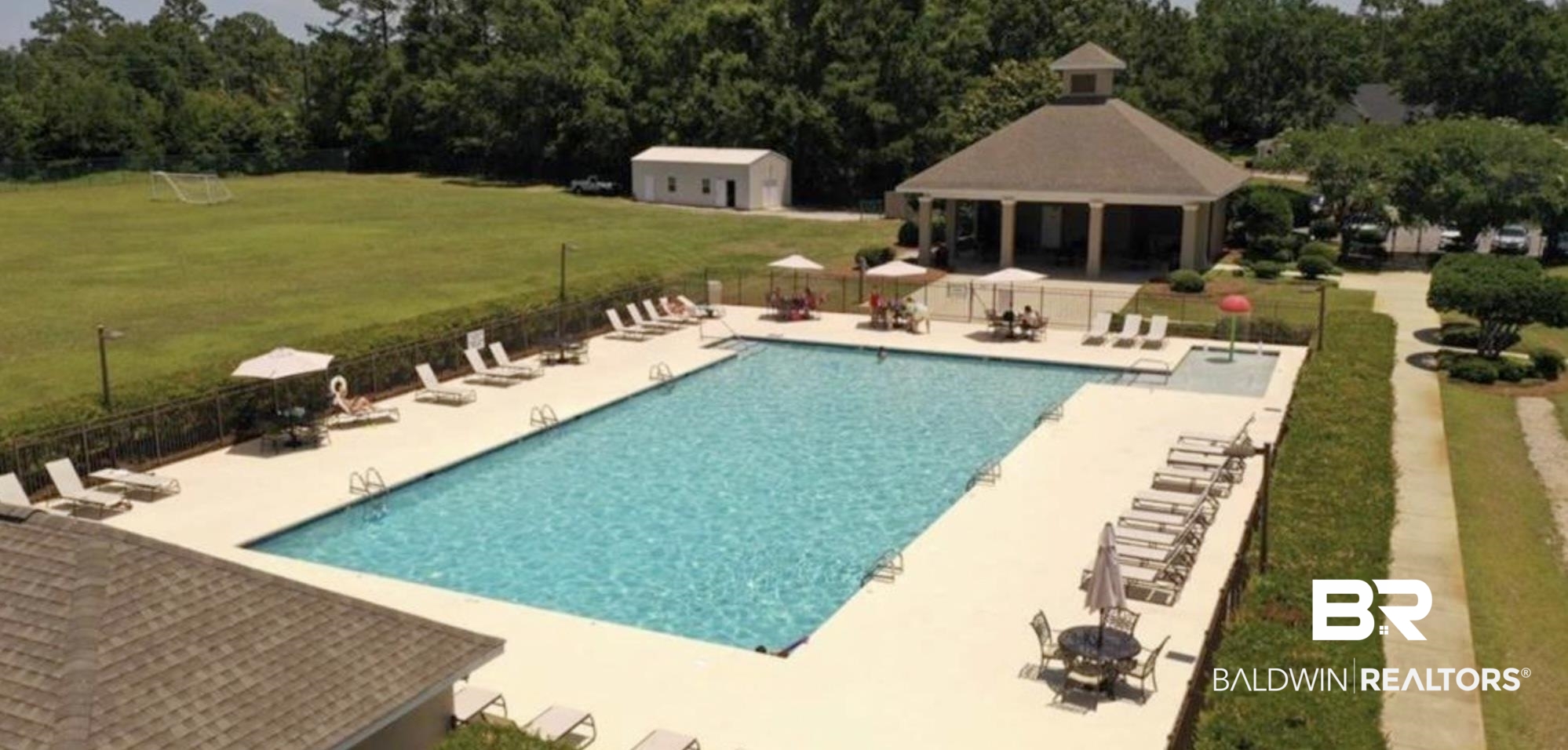 8137 Pine Run Daphne, AL 36527 - Photo 59 of 67 Community swimming pool with an expansive deck, adjacent recreational building, and surrounding green space