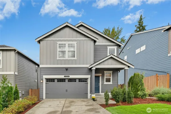 a front view of a house with a yard and garage
