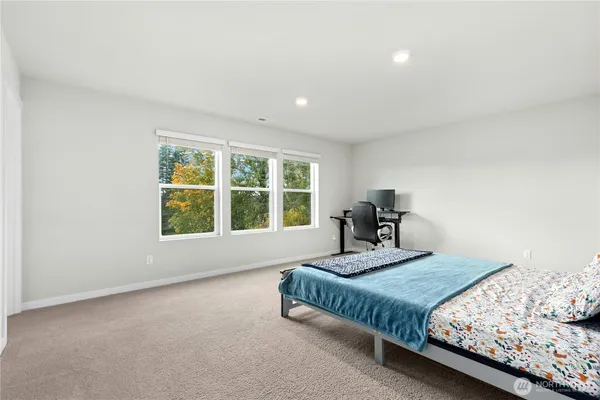 a bed sitting in a bedroom next to a window
