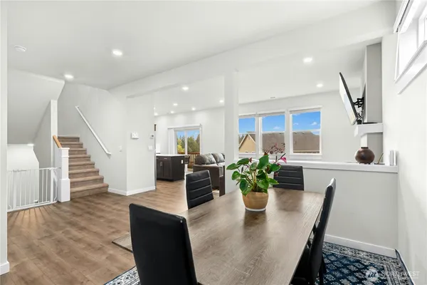 a dining room with furniture and a potted plant