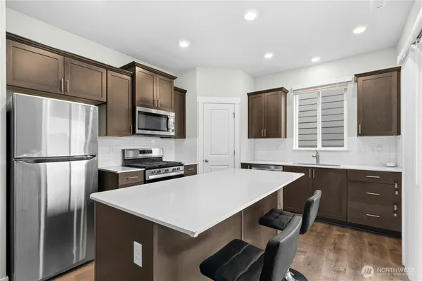 a kitchen with a refrigerator a stove a sink and a microwave