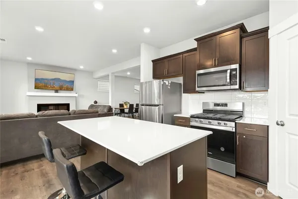 a kitchen with stainless steel appliances a stove sink microwave and cabinets