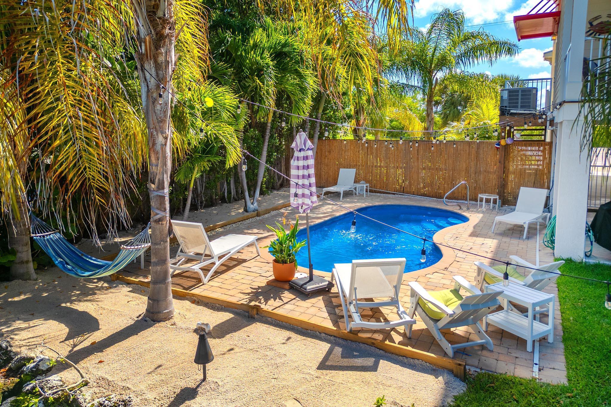 217 Sombrero Beach Road, Unit 1 & 2 Marathon, FL 33050 - Photo 14 of 67 a view of backyard of a house with swimming pool table and chairs