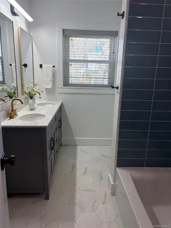 a bathroom with a sink a toilet a window and vanity