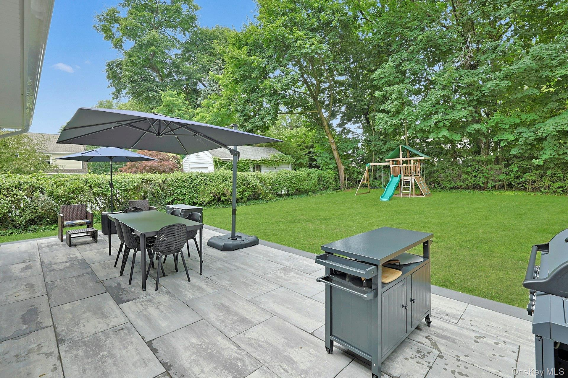 73 Bon Air Avenue New Rochelle, NY 10804 - Photo 21 of 23 a view of a patio with table and chairs under an umbrella