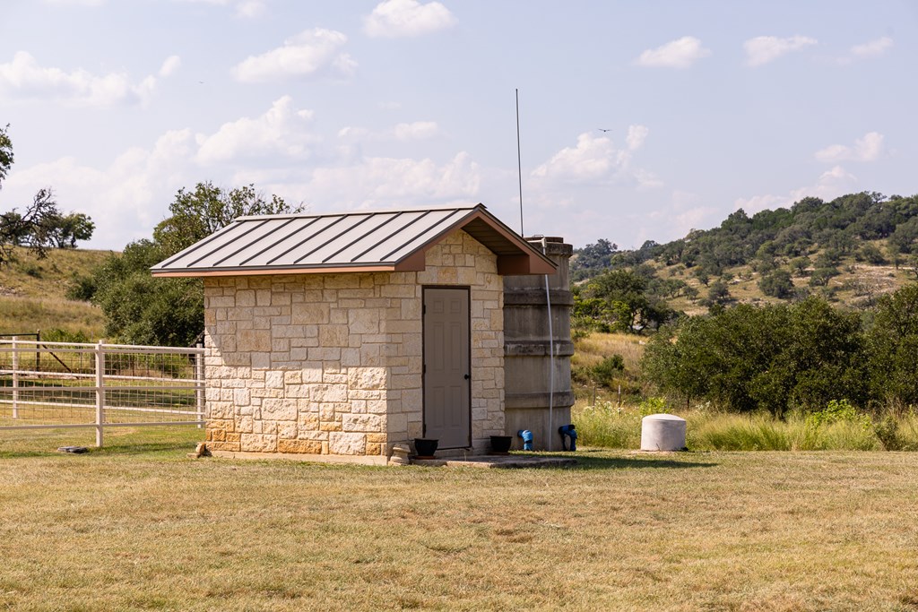 945 Elm Pass Road Center Point, TX 78010 - Photo 11 of 37 Well House and Concrete Storage Tank, 640' deep well pumps 30gpm according to well log.