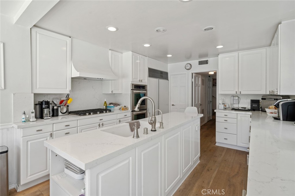 4420 Conchita Way Tarzana, CA 91356 - Photo 30 of 53 a kitchen with white cabinets and stainless steel appliances