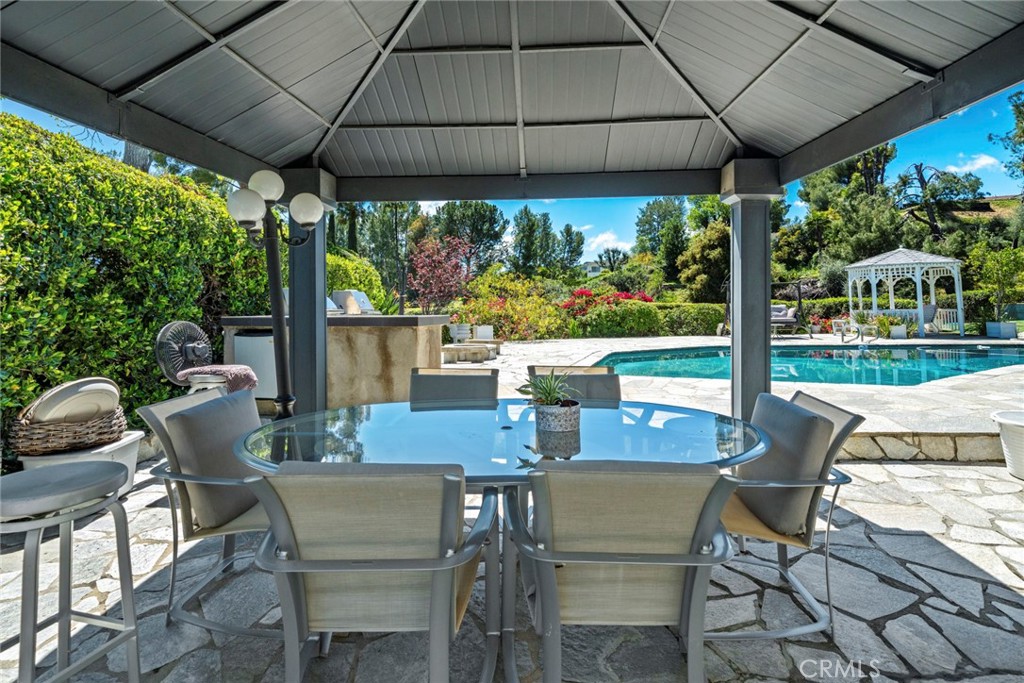 4420 Conchita Way Tarzana, CA 91356 - Photo 41 of 53 a view of an outdoor dining space with a table and chairs under an umbrella