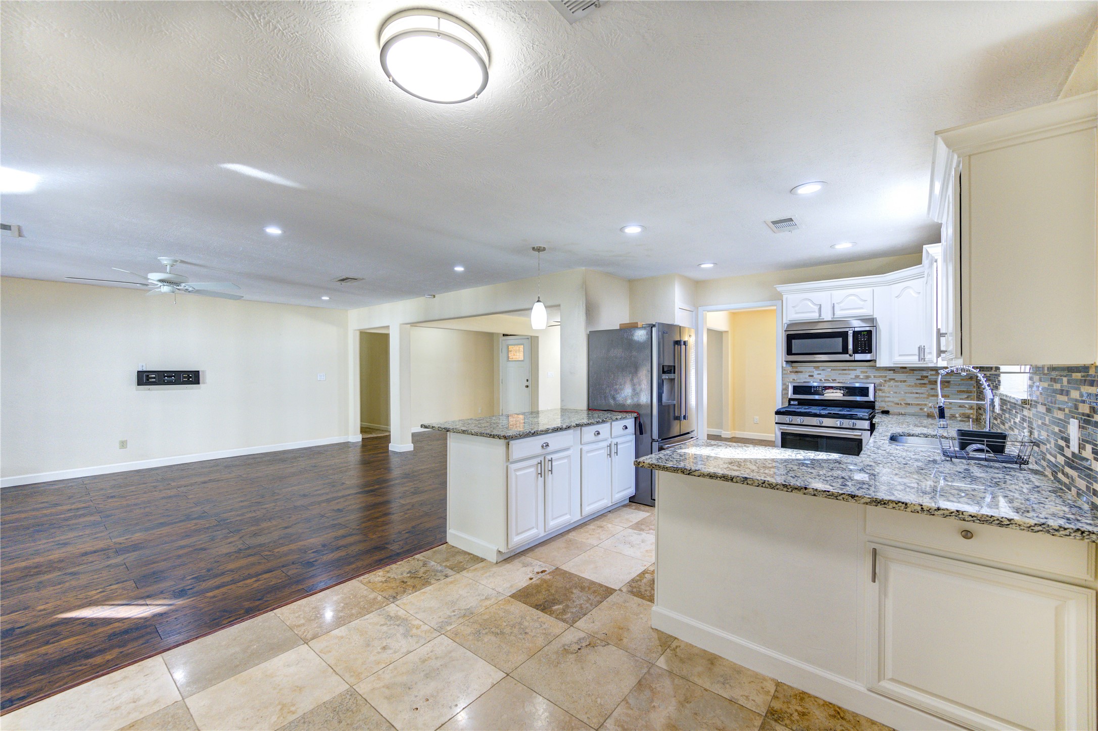 8826 Rowan Lane Houston, TX 77036 - Photo 11 of 26 a large kitchen with stainless steel appliances kitchen island granite countertop a sink and cabinets